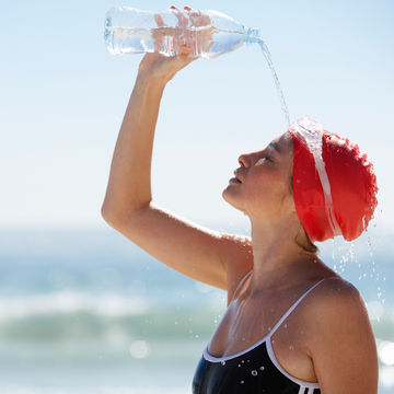 woman-wearing-red-swim-cap-and-goggles-pouring-water-on-her-head-at-the-beach_600x600_42-17458638